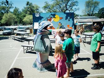 Students gathered around a salmon mascot